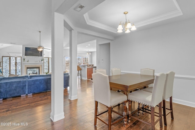 100 Little Acorn Trl, Moyock, NC 27958 - dining area featuring ceiling fan, a tray ceiling, hardwood / wood-style flooring, a chandelier, and baseboards