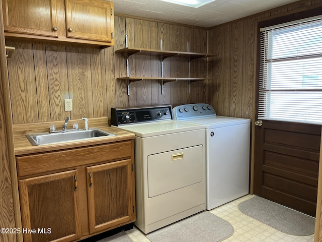 258 Hideaway Rd, Belhaven, NC 27810 - laundry room featuring washing machine and clothes dryer, wood walls, light flooring, and cabinet space