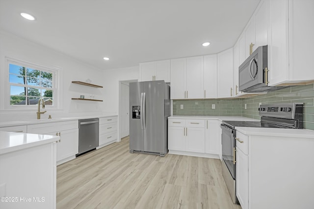 3825 Canterbury Rd, Wilmington, NC 28403 - kitchen featuring appliances with stainless steel finishes, a sink, light wood-style flooring, white cabinetry, and recessed lighting