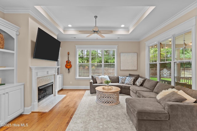 712 Tanbridge Rd, Wilmington, NC 28405 - living area with light wood-style floors, crown molding, a high end fireplace, ceiling fan, and a raised ceiling
