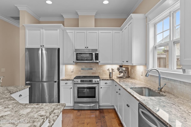 712 Tanbridge Rd, Wilmington, NC 28405 - kitchen with appliances with stainless steel finishes, a sink, white cabinetry, light stone counters, and hardwood / wood-style flooring