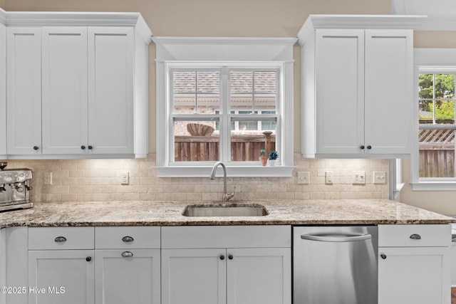 712 Tanbridge Rd, Wilmington, NC 28405 - kitchen with a sink, stainless steel dishwasher, white cabinets, decorative backsplash, and light stone counters