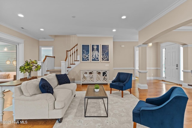 712 Tanbridge Rd, Wilmington, NC 28405 - living room featuring arched walkways, stairs, light wood-style floors, crown molding, and recessed lighting