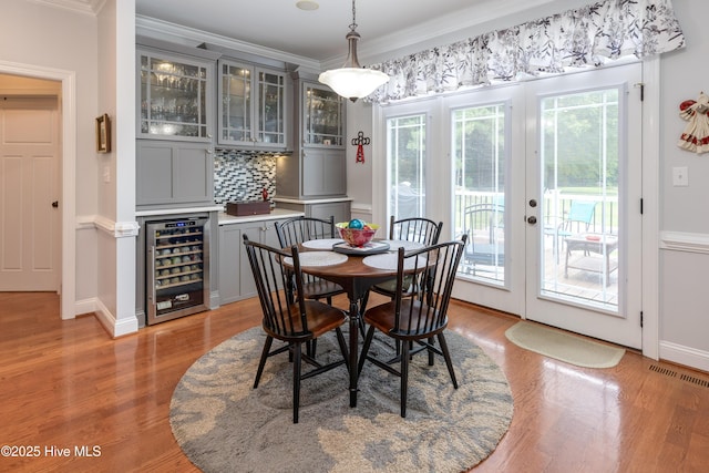 844 E Darden Rd, Faison, NC 28341 - dining space featuring beverage cooler, crown molding, plenty of natural light, light wood-style floors, and a dry bar