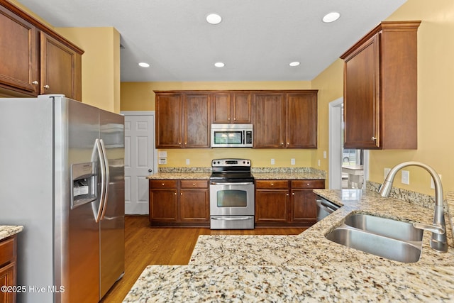 605 Stagecoach Dr, Jacksonville, NC 28546 - kitchen with appliances with stainless steel finishes, a sink, wood finished floors, light stone counters, and recessed lighting