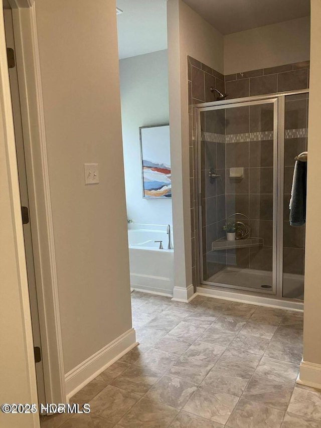 1217 Pelican Dr, New Bern, NC 28560 - bathroom featuring a shower stall, a bath, and baseboards