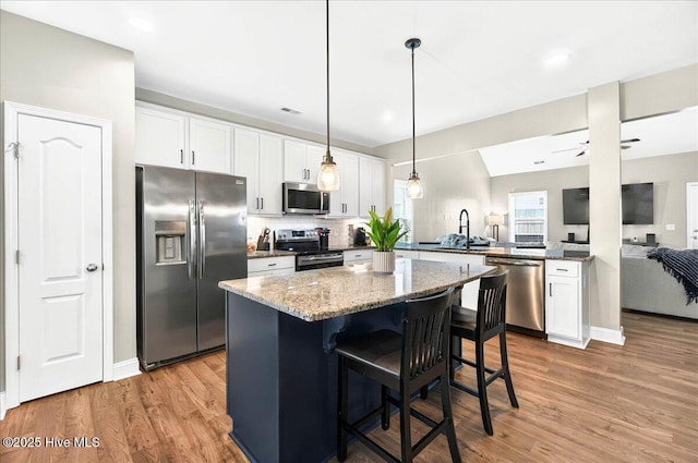 5735 Orchardgrass Rd, Leland, NC 28451 - kitchen with appliances with stainless steel finishes, a sink, light wood-style flooring, white cabinetry, and recessed lighting