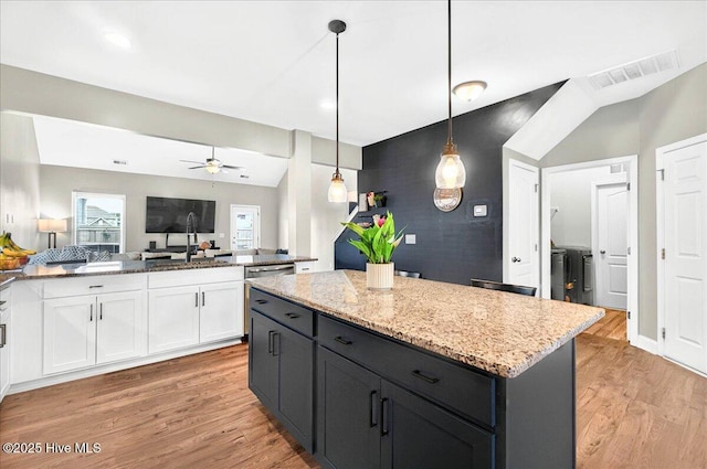 5735 Orchardgrass Rd, Leland, NC 28451 - kitchen featuring white cabinets, a ceiling fan, light wood-style floors, and light stone countertops