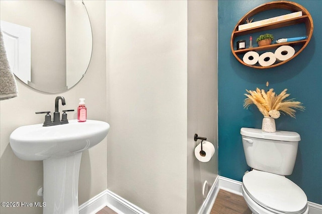 5735 Orchardgrass Rd, Leland, NC 28451 - bathroom featuring toilet, baseboards, wood finished floors, and a sink