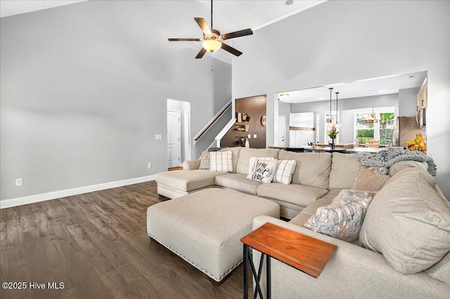 5735 Orchardgrass Rd, Leland, NC 28451 - living room with dark wood finished floors, a ceiling fan, high vaulted ceiling, baseboards, and stairway