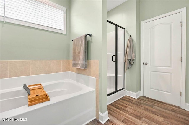 5735 Orchardgrass Rd, Leland, NC 28451 - bathroom featuring a garden tub, a shower stall, wood finished floors, and baseboards