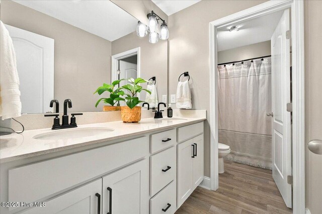 5735 Orchardgrass Rd, Leland, NC 28451 - bathroom with double vanity, toilet, wood finished floors, and curtained shower
