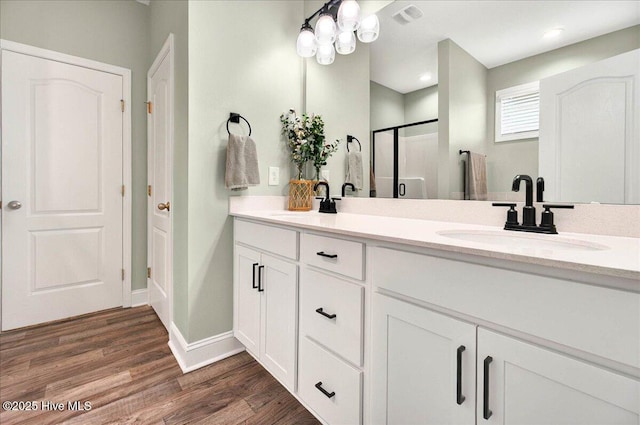 5735 Orchardgrass Rd, Leland, NC 28451 - bathroom featuring double vanity, wood finished floors, a stall shower, and baseboards