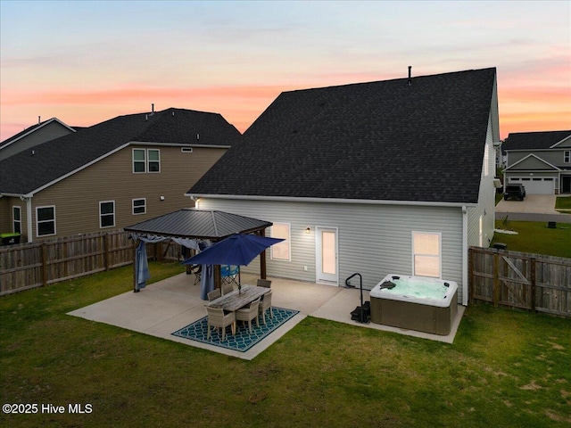 5735 Orchardgrass Rd, Leland, NC 28451 - back of property at dusk with a hot tub, a gazebo, a patio, and roof with shingles