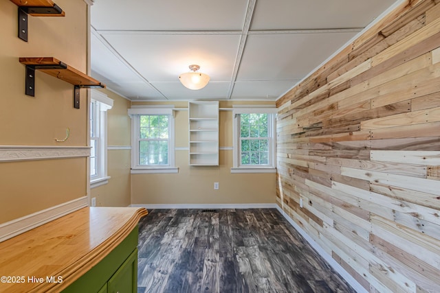 105 Queens Rd, Jacksonville, NC 28540 - unfurnished dining area featuring wood walls, healthy amount of natural light, dark wood-type flooring, and baseboards