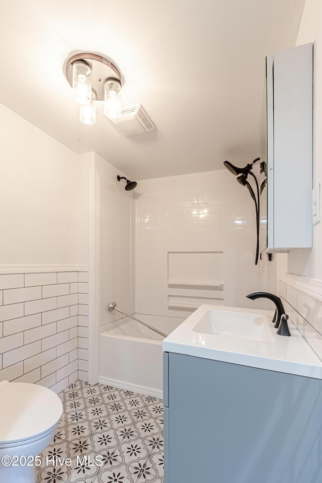 105 Queens Rd, Jacksonville, NC 28540 - full bathroom with tile walls, vanity, toilet, washtub / shower combination, and a wainscoted wall
