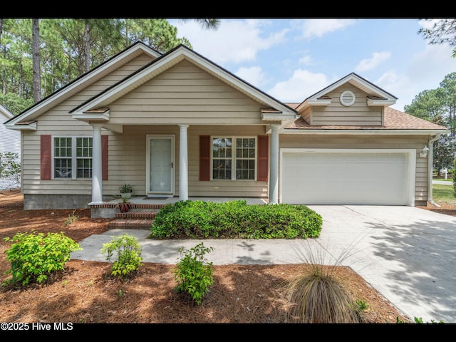 4043 Brick Path Ln SE, Southport, NC 28461 - view of front of home featuring a garage, covered porch, driveway, and a shingled roof
