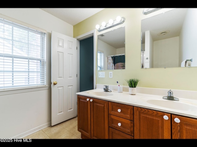 4043 Brick Path Ln SE, Southport, NC 28461 - bathroom with double vanity, tile patterned flooring, and baseboards