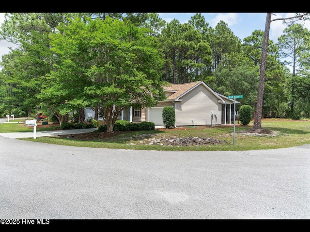 4043 Brick Path Ln SE, Southport, NC 28461 - view of front of home with an attached garage, view of scattered trees, and a front yard