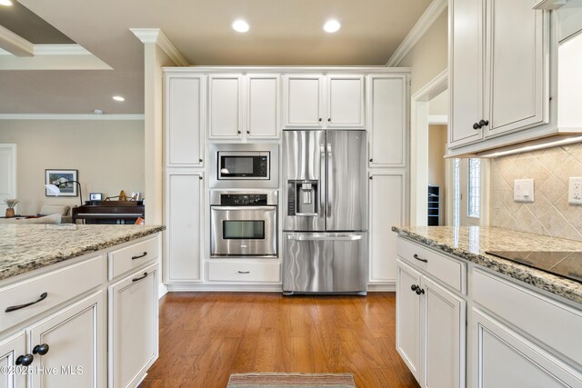 5923 Motts Village Rd, Wilmington, NC 28412 - kitchen featuring appliances with stainless steel finishes, white cabinetry, light wood-type flooring, decorative backsplash, and recessed lighting