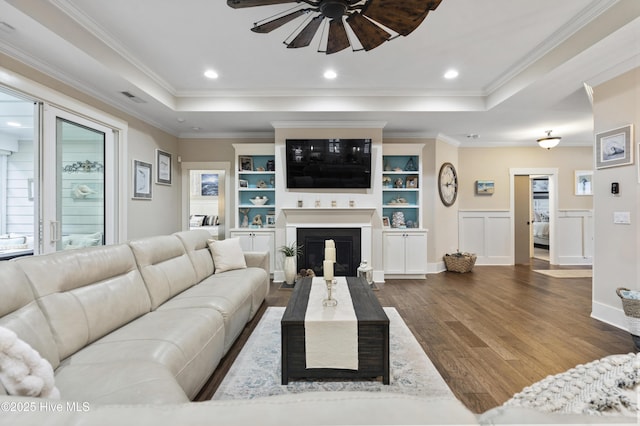 3020 Eno Ln, Leland, NC 28451 - living room featuring ceiling fan, wood finished floors, a raised ceiling, a fireplace, and ornamental molding