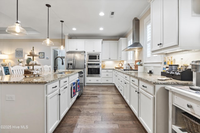 3020 Eno Ln, Leland, NC 28451 - kitchen featuring appliances with stainless steel finishes, wall chimney exhaust hood, a sink, white cabinets, and ornamental molding
