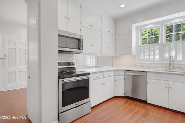 626 Anson Ave, Rockingham, NC 28379 - kitchen with stainless steel appliances, ornamental molding, a sink, backsplash, and light countertops
