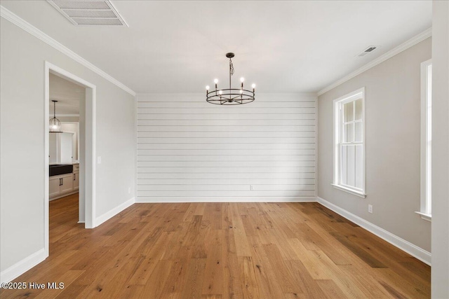 2259 Heartland Rd, Battleboro, NC 27809 - unfurnished dining area featuring a chandelier, light wood-style floors, ornamental molding, and baseboards