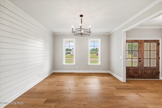2259 Heartland Rd, Battleboro, NC 27809 - unfurnished dining area with a chandelier, light wood finished floors, crown molding, wood walls, and baseboards