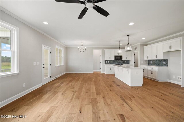 2259 Heartland Rd, Battleboro, NC 27809 - kitchen with stainless steel microwave, plenty of natural light, a sink, tasteful backsplash, and crown molding