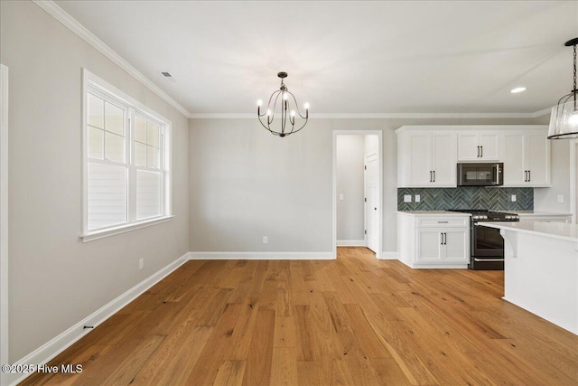 2259 Heartland Rd, Battleboro, NC 27809 - kitchen featuring stainless steel appliances, a chandelier, light countertops, white cabinets, and backsplash