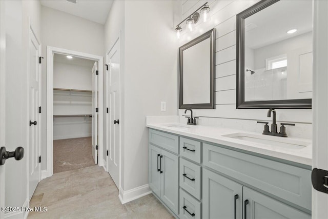 2259 Heartland Rd, Battleboro, NC 27809 - bathroom with double vanity, a tile shower, a walk in closet, baseboards, and recessed lighting