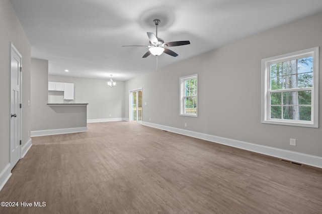 355 N Gaines St, Southern Pines, NC 28387 - unfurnished living room with ceiling fan, a chandelier, baseboards, and light wood finished floors