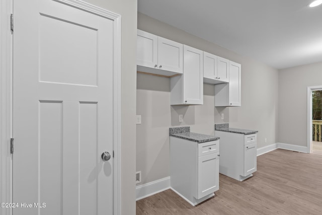 355 N Gaines St, Southern Pines, NC 28387 - kitchen featuring baseboards, light wood-style floors, white cabinetry, and dark stone counters