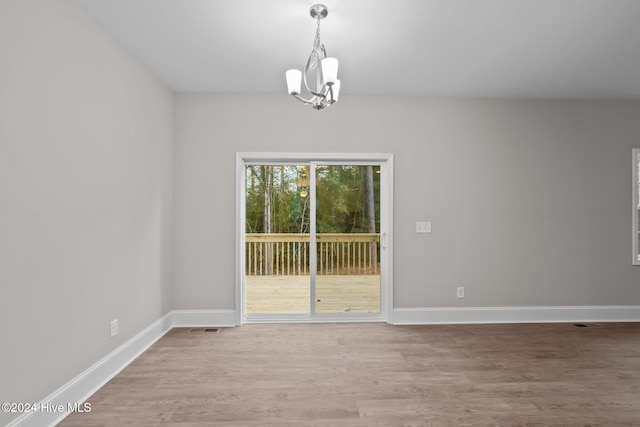 355 N Gaines St, Southern Pines, NC 28387 - unfurnished room with a chandelier, wood finished floors, and baseboards