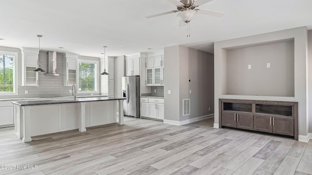290 Boulder Dr, West End, NC 27376 - kitchen with wall chimney range hood, stainless steel fridge, plenty of natural light, and decorative backsplash