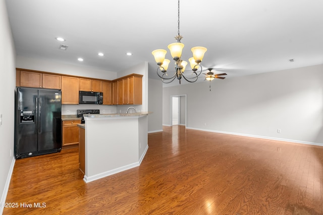280 Coralstone Ct, Leland, NC 28451 - kitchen with black appliances, a chandelier, recessed lighting, wood finished floors, and open floor plan