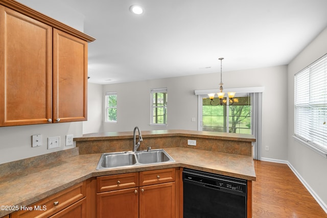 280 Coralstone Ct, Leland, NC 28451 - kitchen featuring dishwasher, a sink, a peninsula, a chandelier, and light wood-style flooring