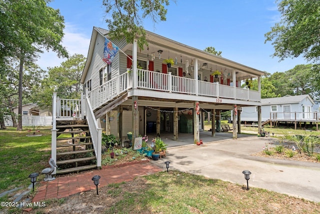 109 NE 1st St, Oak Island, NC 28465 - beach home featuring a carport, stairs, concrete driveway, and a front yard