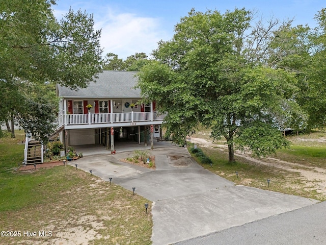 109 NE 1st St, Oak Island, NC 28465 - coastal inspired home featuring concrete driveway, a porch, a carport, stairway, and a shingled roof