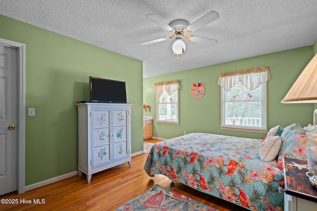 109 NE 1st St, Oak Island, NC 28465 - bedroom with wood finished floors, a textured ceiling, baseboards, and ceiling fan
