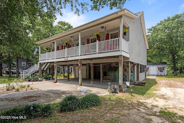 109 NE 1st St, Oak Island, NC 28465 - view of front of house featuring a carport, a porch, driveway, and stairway