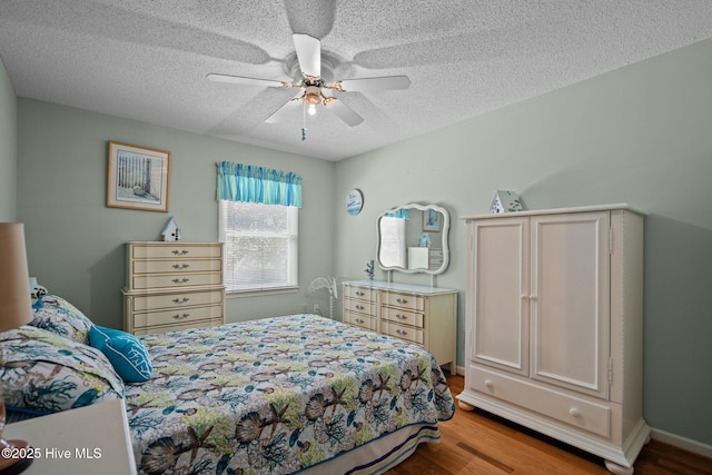 109 NE 1st St, Oak Island, NC 28465 - bedroom with wood finished floors, a textured ceiling, and a ceiling fan