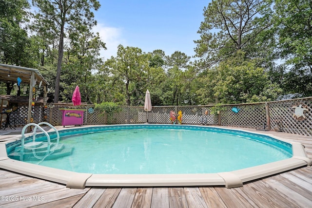 109 NE 1st St, Oak Island, NC 28465 - swimming pool featuring a deck and view of scattered trees