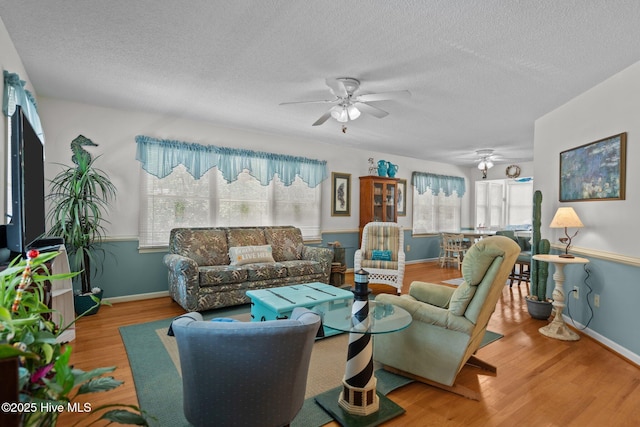 109 NE 1st St, Oak Island, NC 28465 - living area featuring ceiling fan, wood finished floors, a textured ceiling, and baseboards