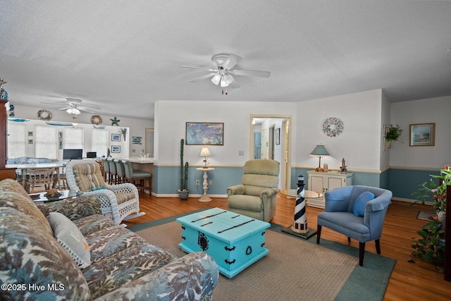 109 NE 1st St, Oak Island, NC 28465 - living area featuring a ceiling fan, wood finished floors, a textured ceiling, and baseboards