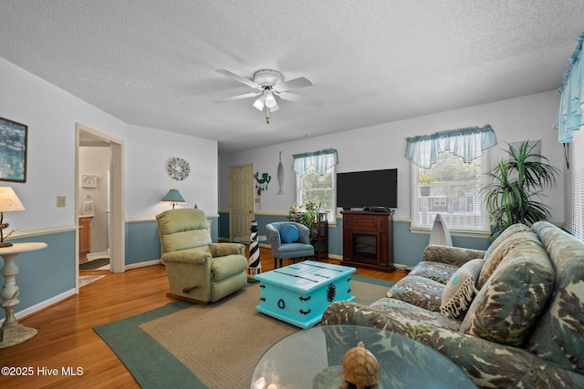 109 NE 1st St, Oak Island, NC 28465 - living area with a ceiling fan, a textured ceiling, wood finished floors, a fireplace, and baseboards