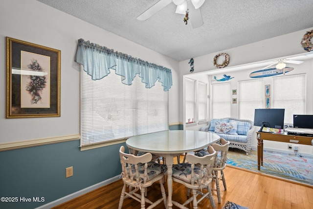 109 NE 1st St, Oak Island, NC 28465 - dining room with a ceiling fan, a textured ceiling, hardwood / wood-style flooring, and baseboards