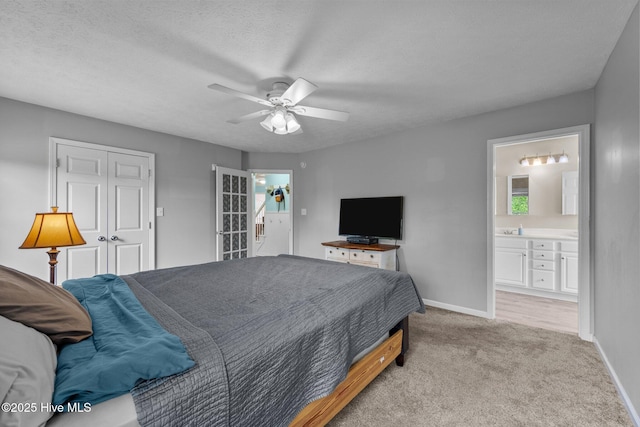 206 Lansing Ct, Jacksonville, NC 28540 - bedroom with baseboards, light carpet, ensuite bathroom, ceiling fan, and a textured ceiling