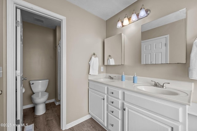 206 Lansing Ct, Jacksonville, NC 28540 - bathroom with double vanity, wood finished floors, baseboards, and toilet